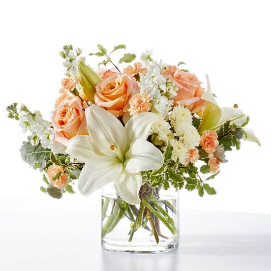 A bouquet of peach roses, white lilies, and white stock with same-day delivery in Miami.